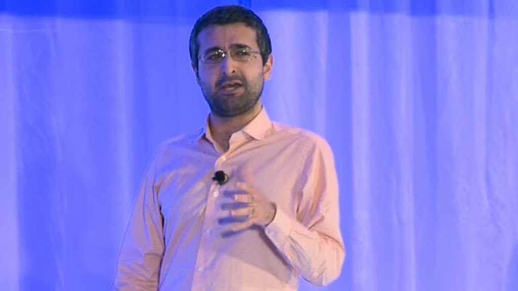 Male talking with his hand outstretched.